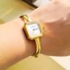 Elegant gold square bangle watch for women with a minimalist white dial and polished bracelet.