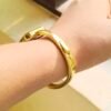 Elegant gold square bangle watch for women with a minimalist white dial and polished bracelet.