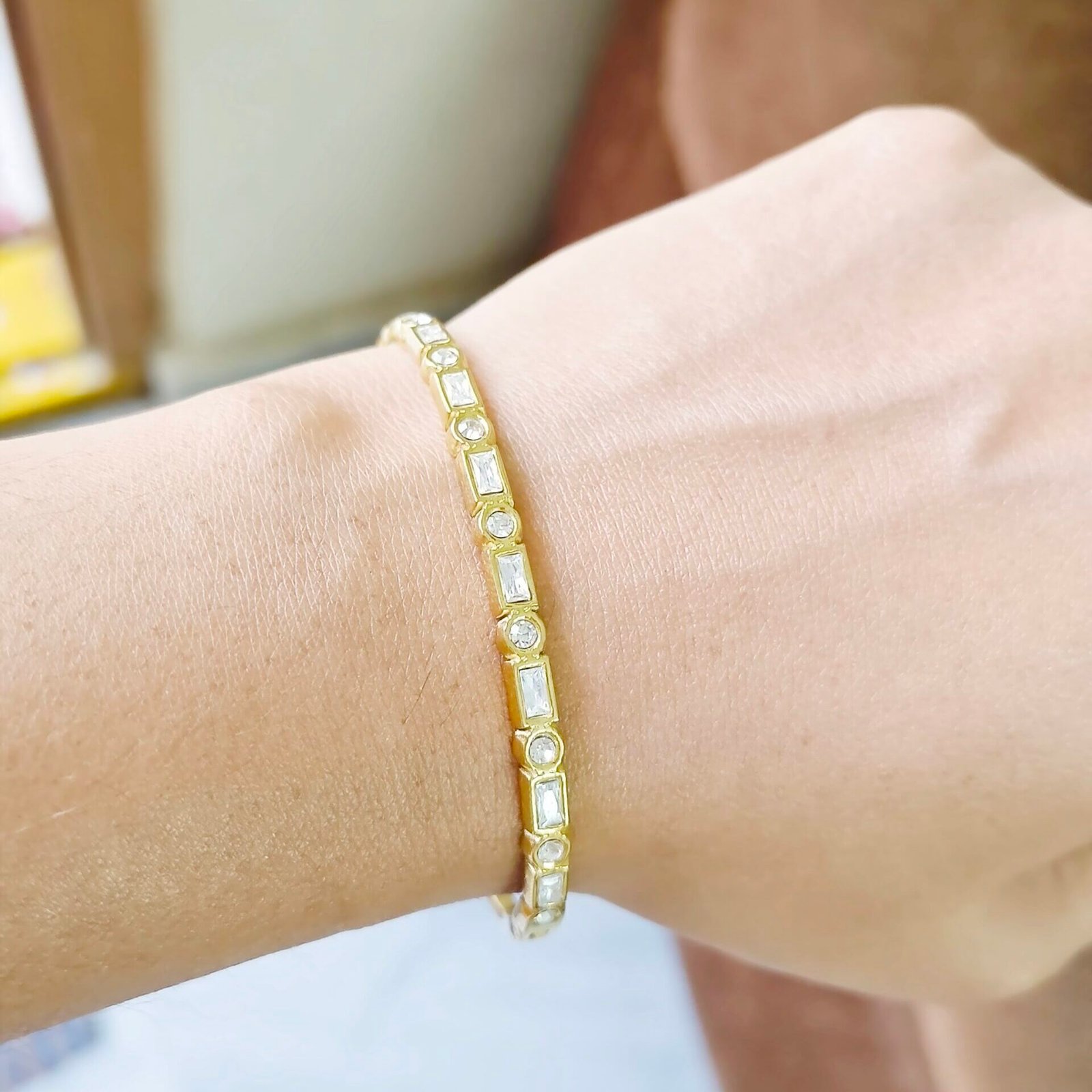 Aurora Prism Kada featuring baguette and round crystal accents in a gold-tone finish.