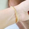 Aurora Prism Kada featuring baguette and round crystal accents in a gold-tone finish.