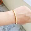 Elegant gold-tone slim kada bracelet with crystal stone accents for women.