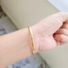 Elegant gold-tone slim kada bracelet with crystal stone accents for women.